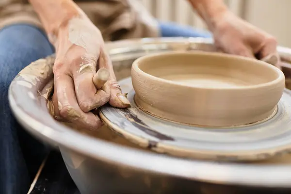 Hands expertly shape clay on the potters wheel in a bright and inviting pottery studio. — Stock Photo