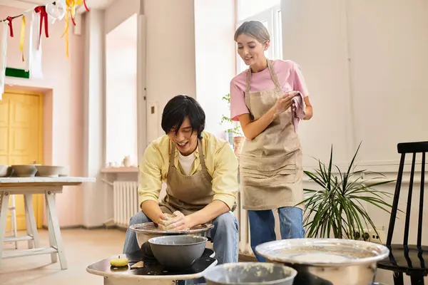 A young couple crafts pottery, sharing smiles and romantic moments in a bright studio. — Stock Photo