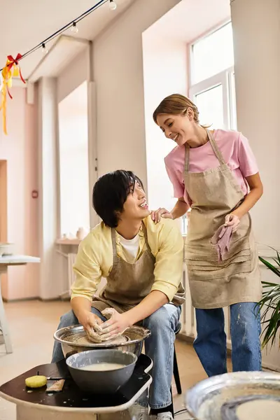 A couple enjoys their time as they shape clay into pottery in a bright and cozy studio setting. — Stock Photo