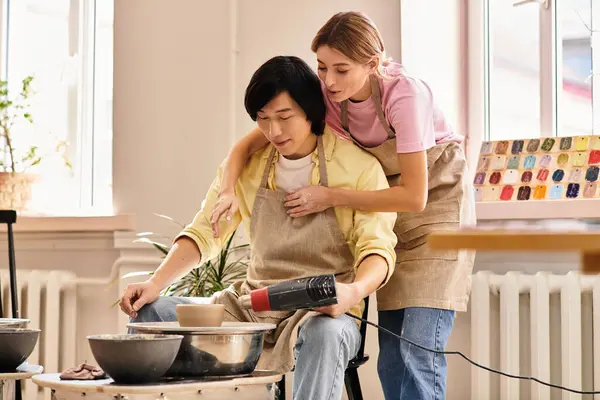 A young couple creatively bonds while making pottery in a vibrant studio. — Stock Photo