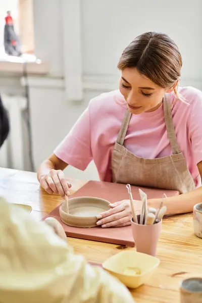 A young couple enjoys pottery making together, focusing on their designs with love and creativity. — Stock Photo