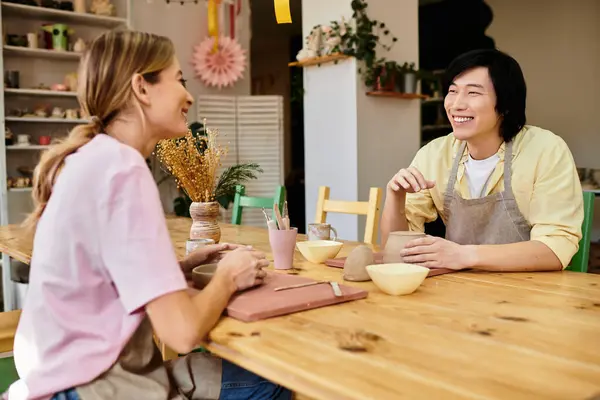 A young couple joyfully creates pottery together in a vibrant studio, surrounded by art and love. — Stock Photo