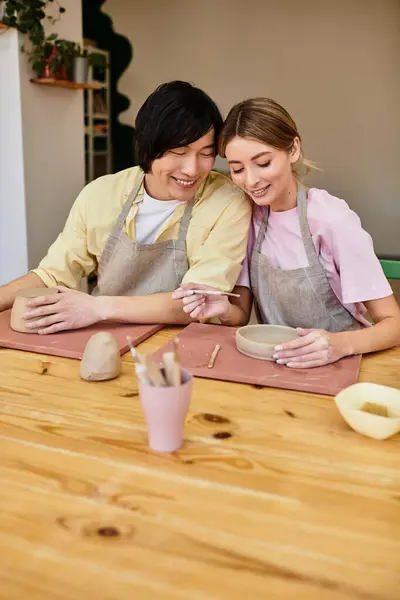 A young couple enjoys a creative pottery session, sharing laughter and artistic moments. — Stock Photo