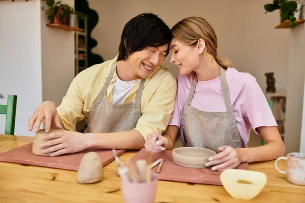 A young couple crafts pottery together in a charming studio, sharing joy and creativity. — Stock Photo
