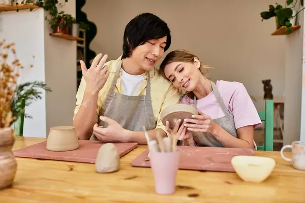 A young couple enjoys quality time while crafting pottery together in a charming art studio. — Stock Photo
