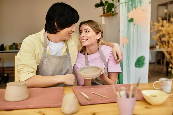 A young couple joyfully engages in pottery, crafting together in a welcoming studio atmosphere. — Stock Photo