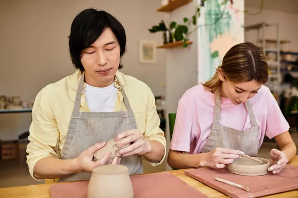 A young couple engaged in pottery making, sharing love and creativity in a warm studio. — Stock Photo