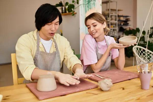 Young couple enjoys crafting pottery together, sharing laughs and creativity at the studio. — Stock Photo