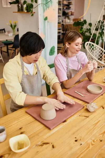 Una joven pareja artesanía feliz cerámica única en un acogedor estudio juntos. - foto de stock