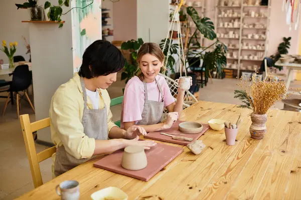 A young couple enjoys a fun pottery session in a colorful studio, crafting clay pieces together. — Stock Photo
