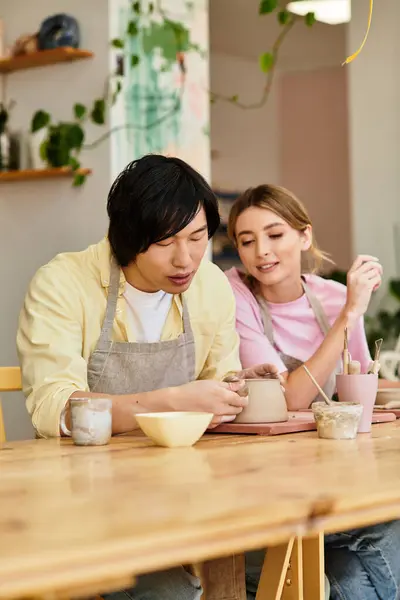 Young couple crafts pottery together, sharing laughter and art in a bright studio. — Stock Photo