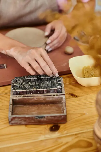 Hands mold clay amid tools in a warm studio, highlighting creativity. — Stock Photo
