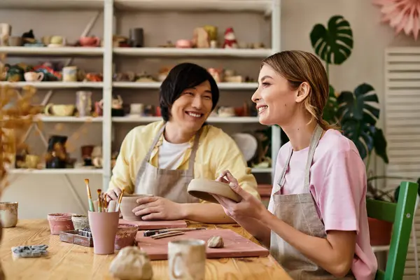 A young couple shares laughter and joy while working on pottery, connecting through art and love. — Stock Photo
