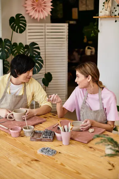 Young couple enjoys each others company as they craft pottery together in an inviting art studio — Stock Photo