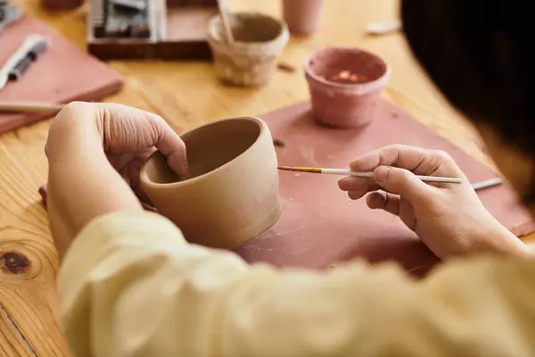 Hands crafting and painting pottery in a bright, creatively vibrant studio. — Stock Photo