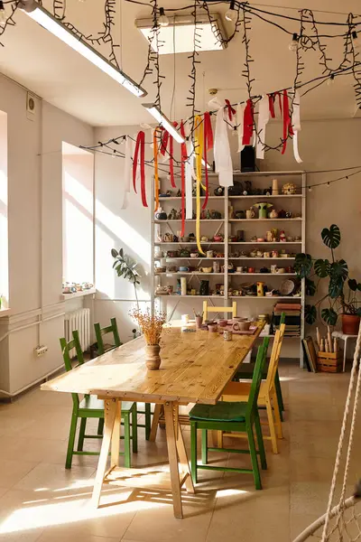 Sunlight brightens a vibrant pottery studio filled with colorful chairs and art supplies. — Stock Photo