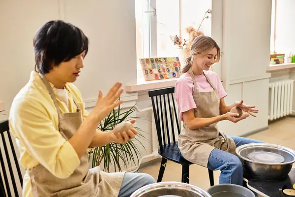 A young couple joyfully creates ceramic art together, celebrating love and creativity. — Stock Photo