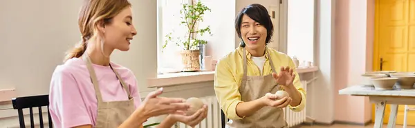 A young couple joyfully crafts pottery in a warm, creative studio. — Stock Photo
