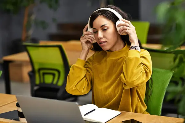 A focused professional wears headphones in a sleek, modern workspace. — Stock Photo