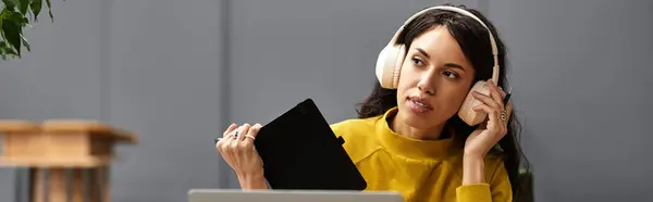 Bella donna che indossa le cuffie si impegna con il suo tablet mentre immerso in compiti di ufficio. — Foto stock