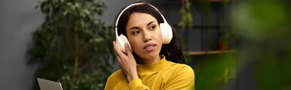 Beautiful professional woman working diligently in a modern office setting, wearing headphones. — Stock Photo