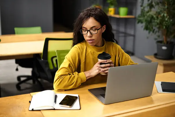 Elegant woman in a cozy workspace focuses on her tasks while enjoying a warm beverage. — Stock Photo