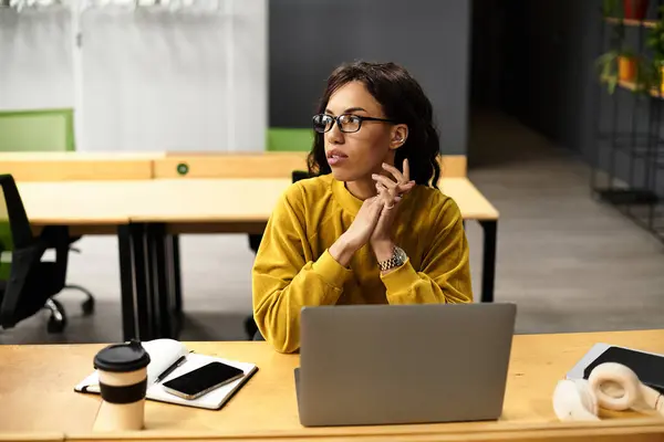Joven profesional reflexionando sobre las ideas en su elegante escritorio de oficina rodeado de decoración moderna - foto de stock
