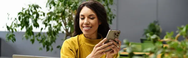 Focused and stylish young woman interacts with her smartphone during a work session in the office. — Stock Photo