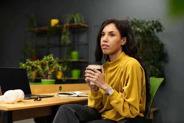 Brightly colored workspace features a beautiful woman contemplating her ideas with a cup in hand. — Stock Photo