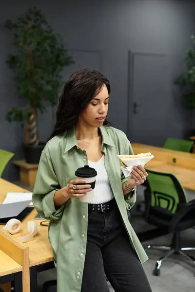 Junge Frau mit elegantem Stil nimmt sich einen Moment Zeit, um Essen und Kaffee im Büro zu genießen. — Stockfoto