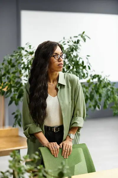 A stylish young woman engages in a meeting in a modern office filled with plants. — Stock Photo