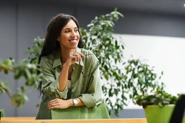 Beautiful woman thoughtfully discusses ideas while standing in a vibrant office environment. — Stock Photo