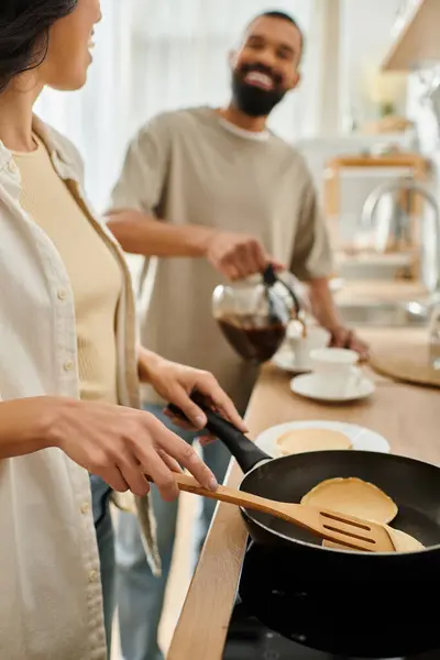 Couple enjoys a cozy breakfast experience, sharing laughter and love while cooking together. — Stock Photo