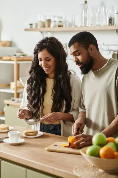 A joyful couple prepares a delightful breakfast in their cozy kitchen, laughing and bonding. — Stock Photo