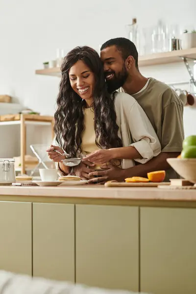 A couple shares loving smiles in a cozy kitchen while preparing a meal together. — Stock Photo