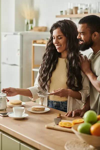 A couple shares smiles while preparing breakfast in their cozy kitchen. — Stock Photo
