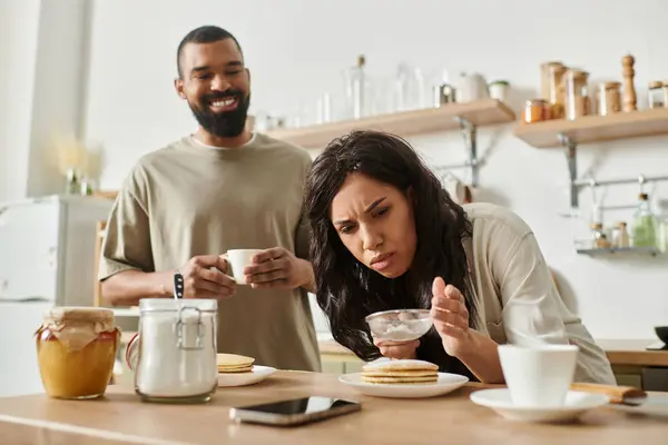 Una cucina accogliente mostra una coppia che cucina gioiosamente insieme e condivide momenti speciali. — Foto stock