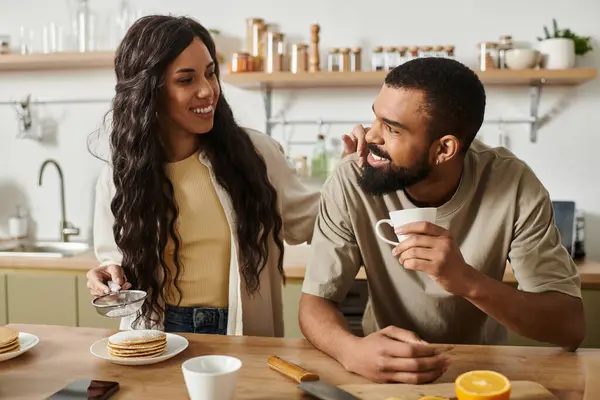 Sweet moments unfold as a loving couple prepares breakfast together, savoring their time at home. — Stock Photo