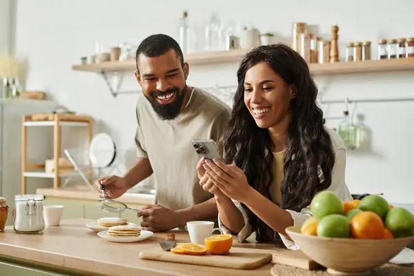 In a bright kitchen, a couple shares laughter over delicious breakfast delights. — Stock Photo