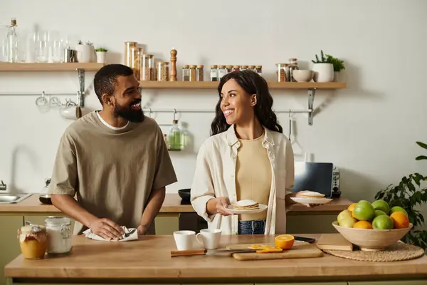 Una coppia gode di tempo di qualità facendo colazione insieme nella loro cucina luminosa. — Foto stock