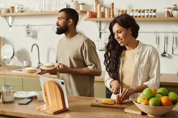 A loving couple shares joyful moments cooking together in their cozy kitchen. — Stock Photo