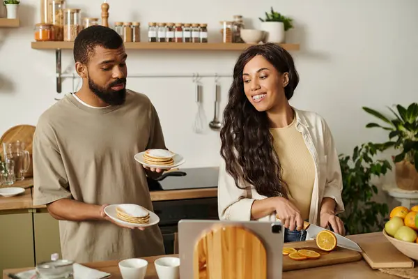Loving couple enjoys each others company while preparing delicious food in their cozy kitchen. — Stock Photo