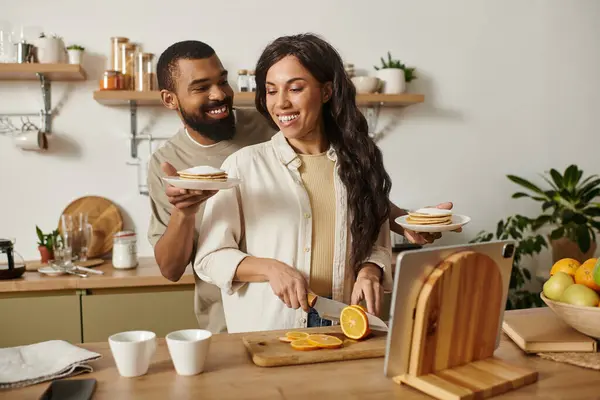A joyful couple makes a delicious breakfast together, sharing love in their kitchen. — Stock Photo