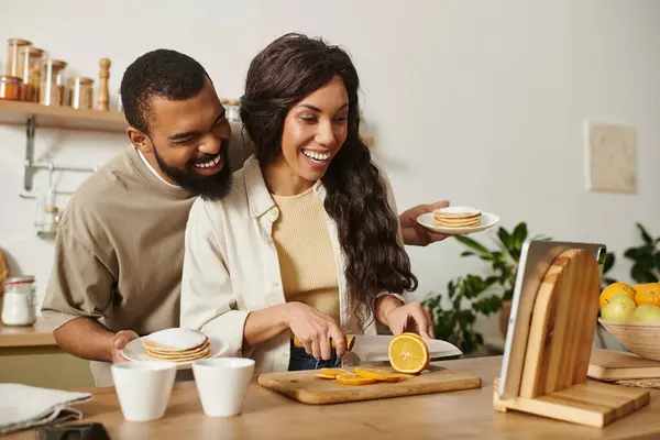 Una coppia felice si gode la compagnia mentre prepara la colazione a casa. — Foto stock