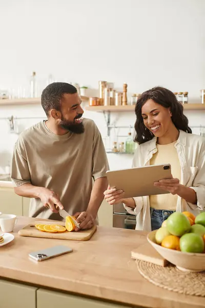 Un couple noir affectueux partage des sourires et du temps de qualité dans leur cuisine confortable. — Photo de stock