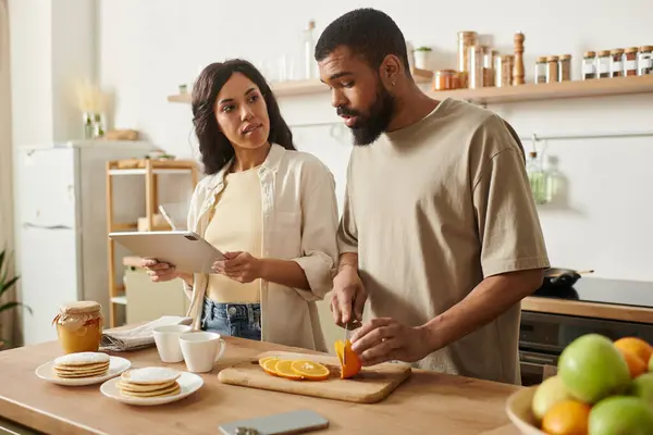 Una gioiosa coppia afroamericana condivide un momento speciale preparando la colazione insieme. — Foto stock