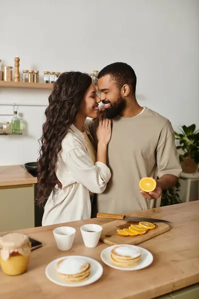 A sweet couple shares a warm moment while preparing breakfast together in their inviting kitchen. — Stock Photo