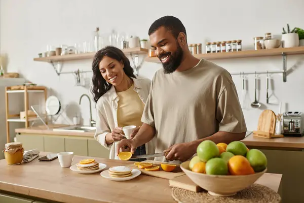 A man and woman joyfully prepare breakfast together, creating a loving atmosphere in their home. — Stock Photo