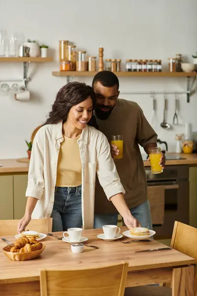 A couple shares breakfast and laughter at home, making warm morning memories together. — Stock Photo