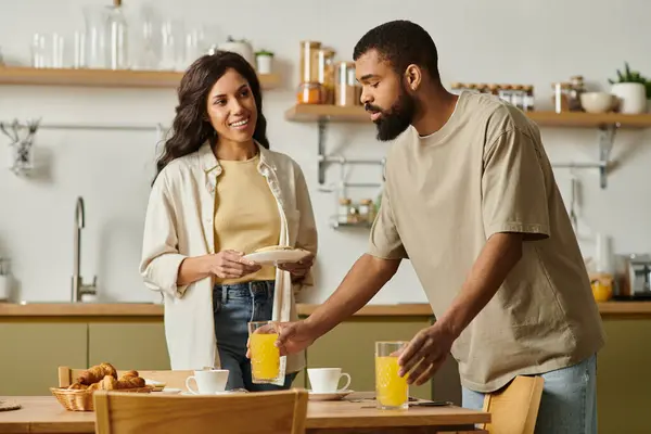 An African American couple enjoys a cozy breakfast ritual, sharing smiles in their kitchen. — Stock Photo